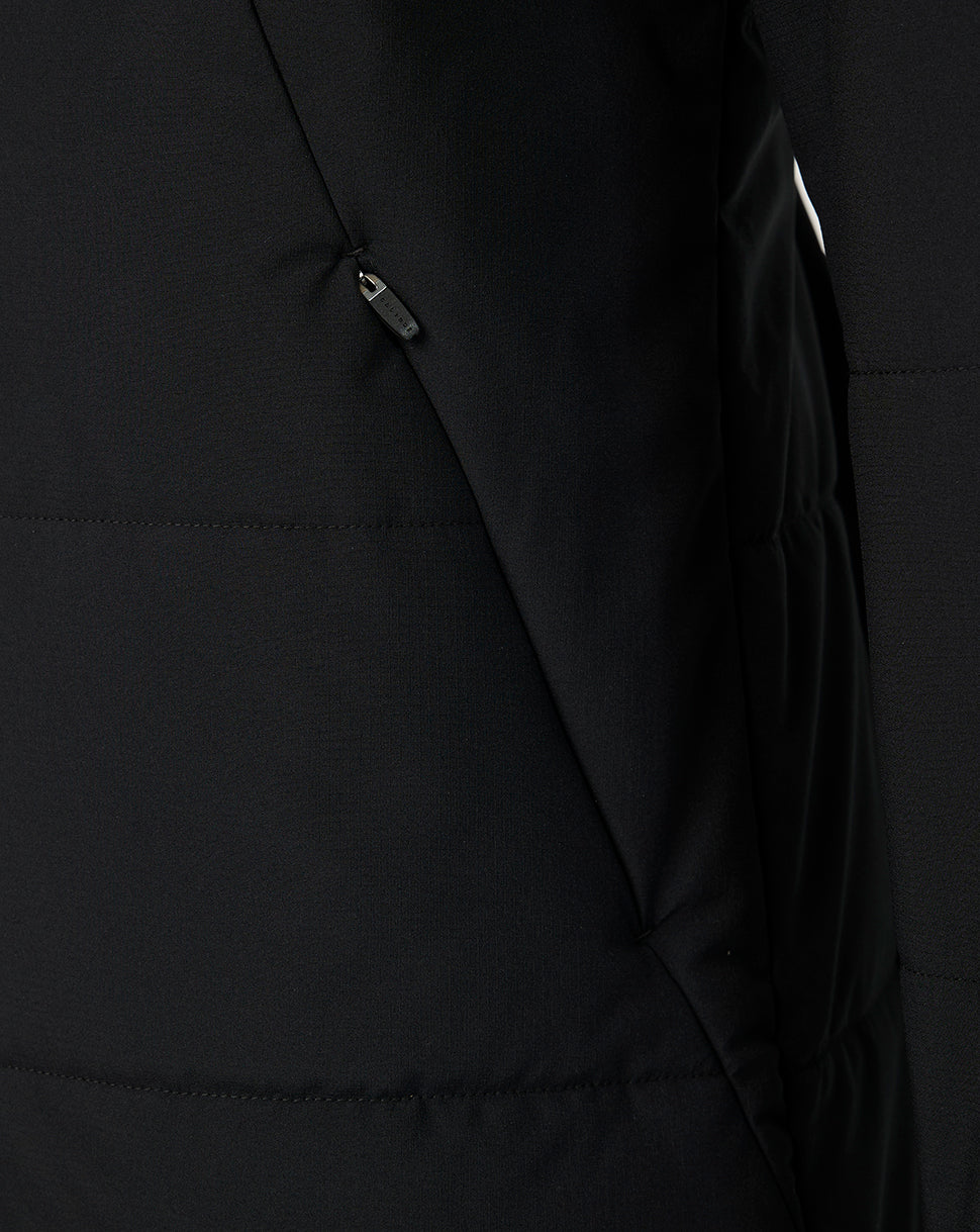 Close-up of a black puffer jacket showing a zippered pocket and quilted stitching.