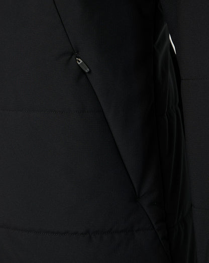 Close-up of a black puffer jacket showing a zippered pocket and quilted stitching.