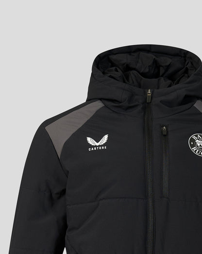 A close-up of a black hooded puffer jacket with gray shoulder panels, featuring a white Castore wing logo on the left chest and a circular crest on the right chest, set against a solid light gray background.
