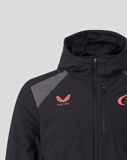 A close-up of a black hooded jacket with gray shoulder panels, featuring a pink Castore wing logo on the left chest and a partial pink logo on the right chest, set against a light gray background.
