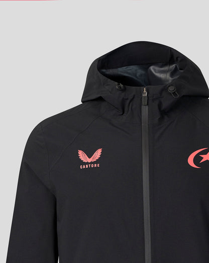 A close-up of a black hooded jacket featuring a pink winged logo with the word 'CASTORE' on the left chest and a pink crescent logo on the right chest, set against a solid light gray background.