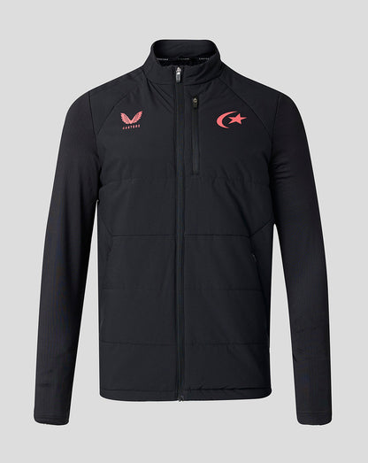 A black full-zip jacket with a high collar, featuring a red Saracens logo on the left chest and a red winged emblem with the word 'Castore' on the right chest, displayed against a solid gray background.
