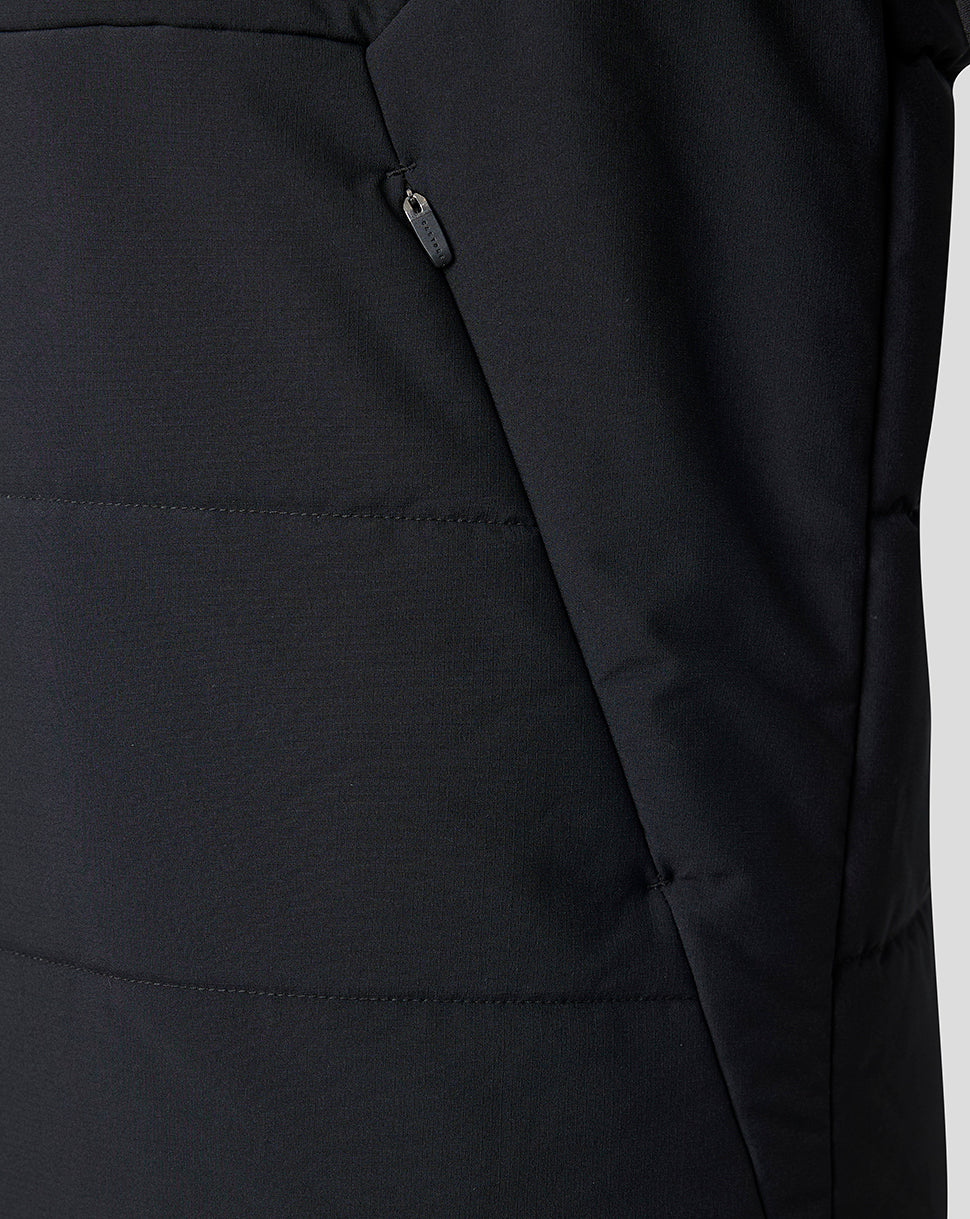 Close-up of a black puffer jacket showing horizontal quilted stitching, a side zippered pocket, and a dark zipper pull.