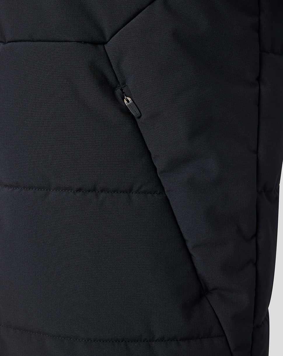 Close-up of a black quilted puffer jacket showing the fabric texture and a zippered pocket detail.