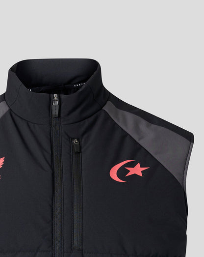 Close-up of a black sleeveless zip-front vest with dark gray shoulder panels and a red crescent and star logo on the left chest, shown against a light gray background.