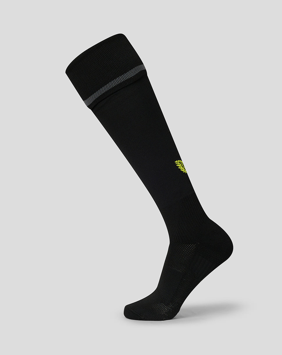 A single black knee-high athletic sock with a small yellow logo on the side and a gray ribbed band at the top cuff, shown against a solid light gray background.