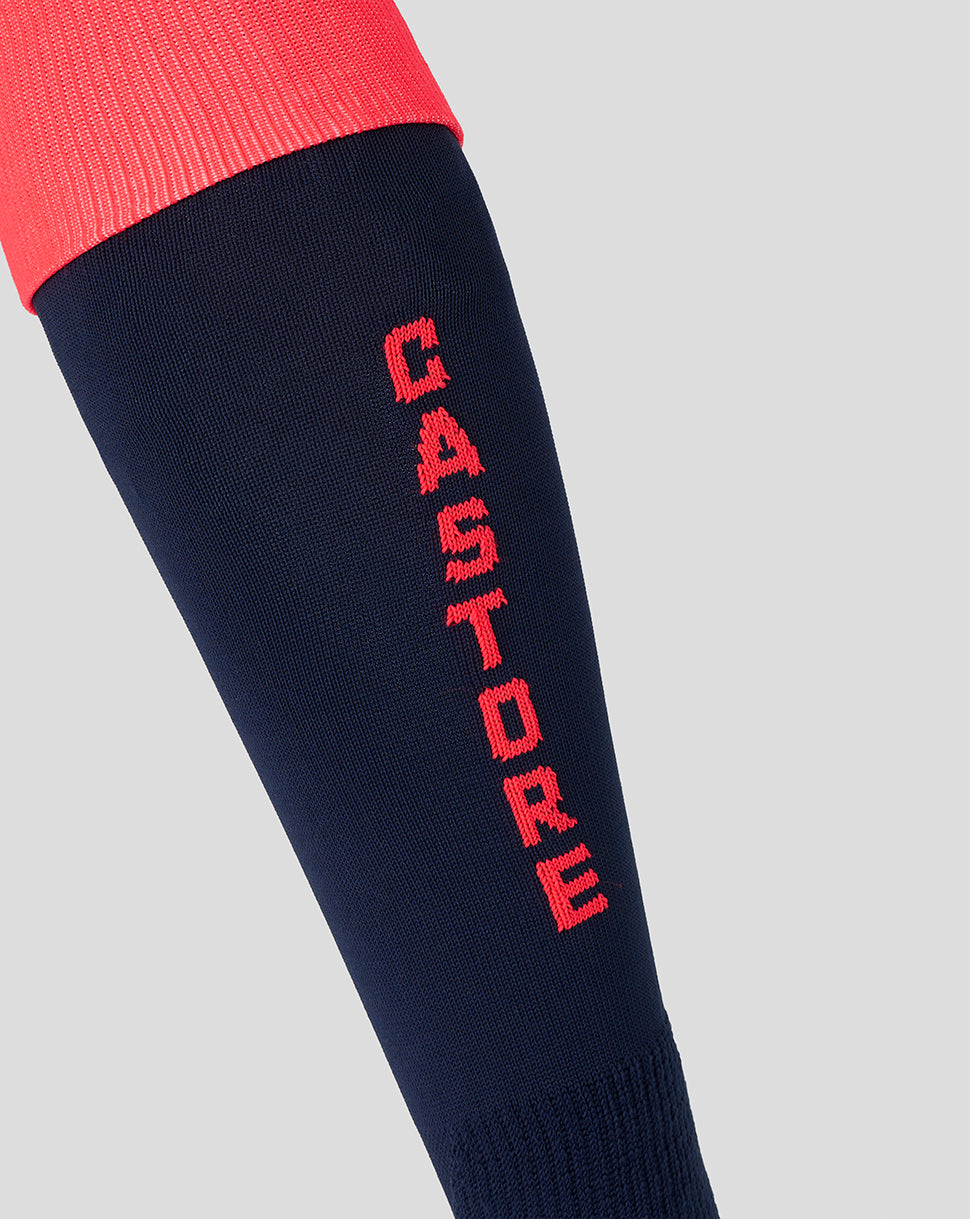 Navy sock with red 'Castore' branding on a light gray background