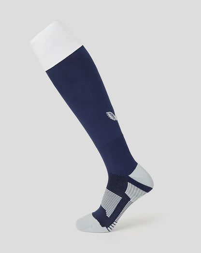 Navy knee-high sock with white cuff on a light gray background