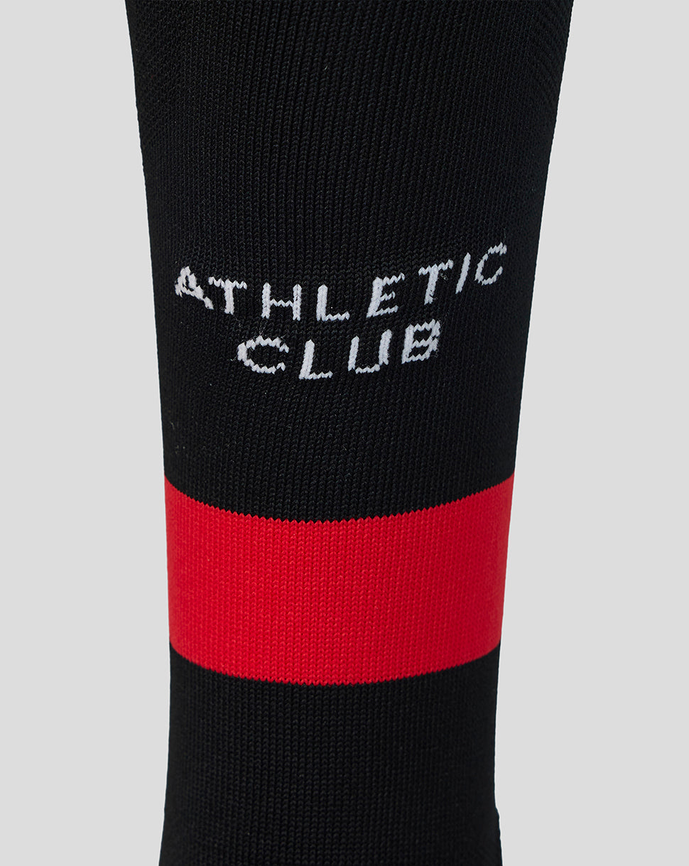 Close up of white Athletic Club lettering on black sock with a bold red band.