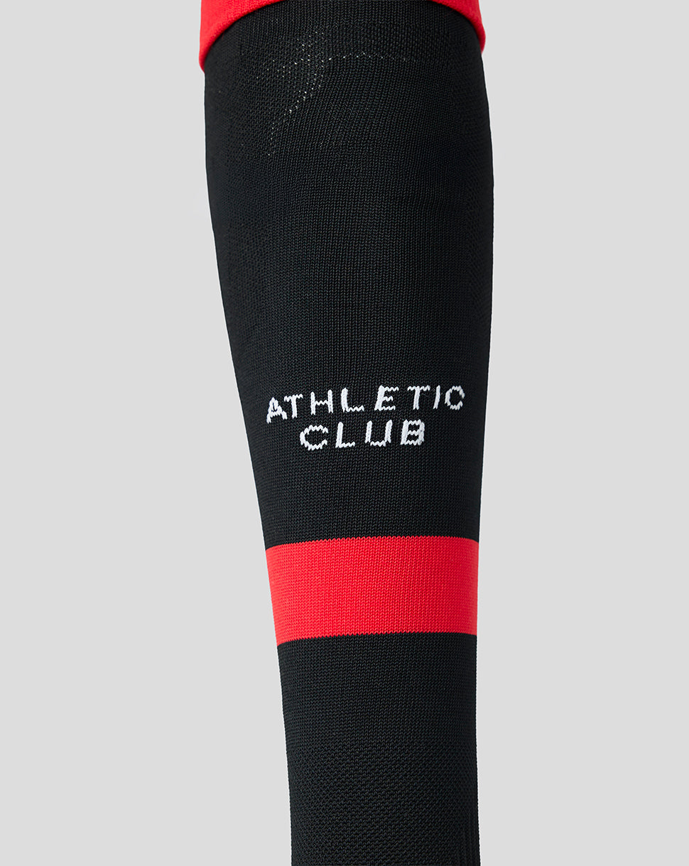Close up of black Athletic Club footless sock with white ATHLETIC CLUB lettering and a red stripe.