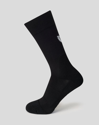 Black sock with a brand logo on a light gray background