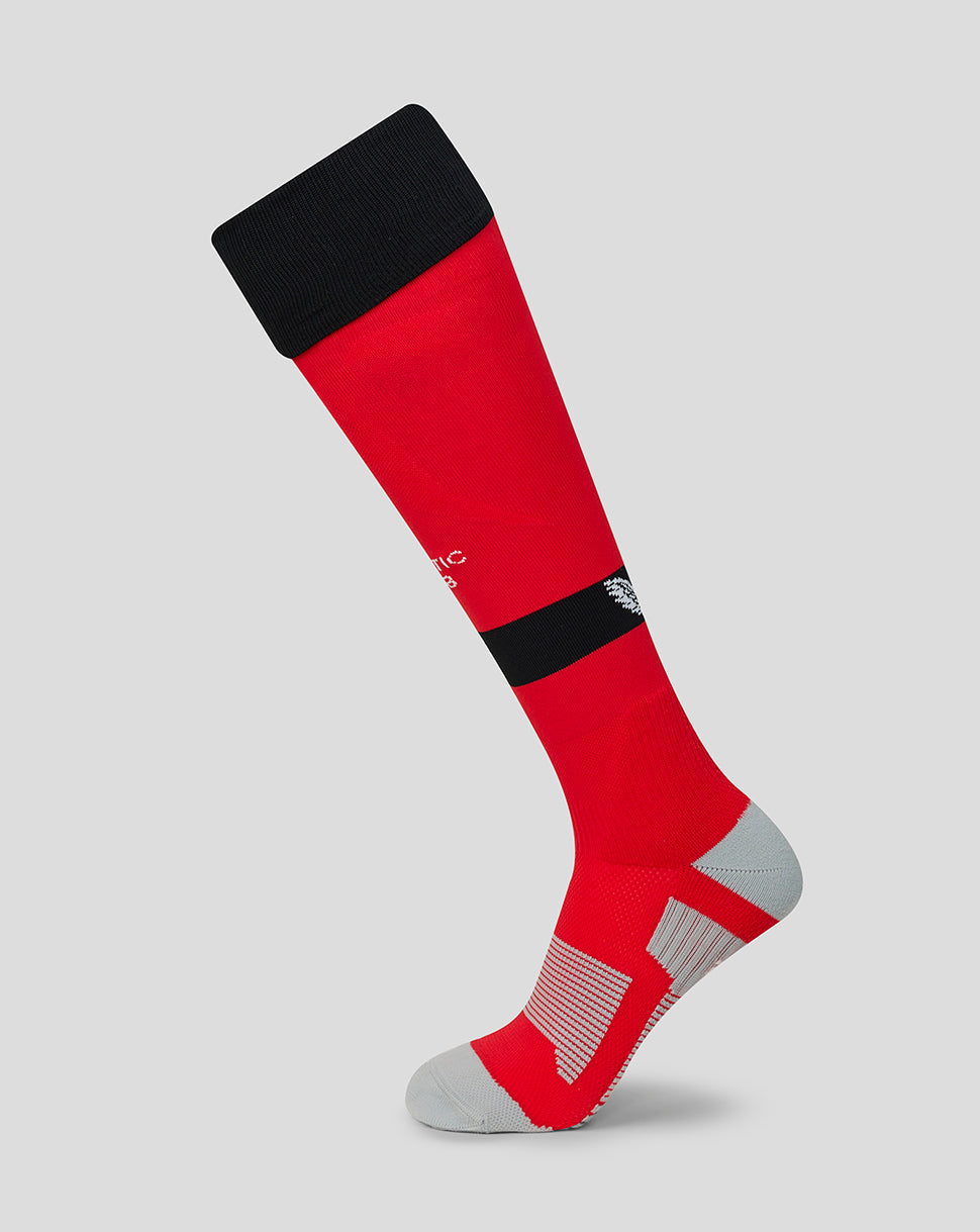 Red away sock with black cuff and band, white logo on the band and gray heel and toe details.