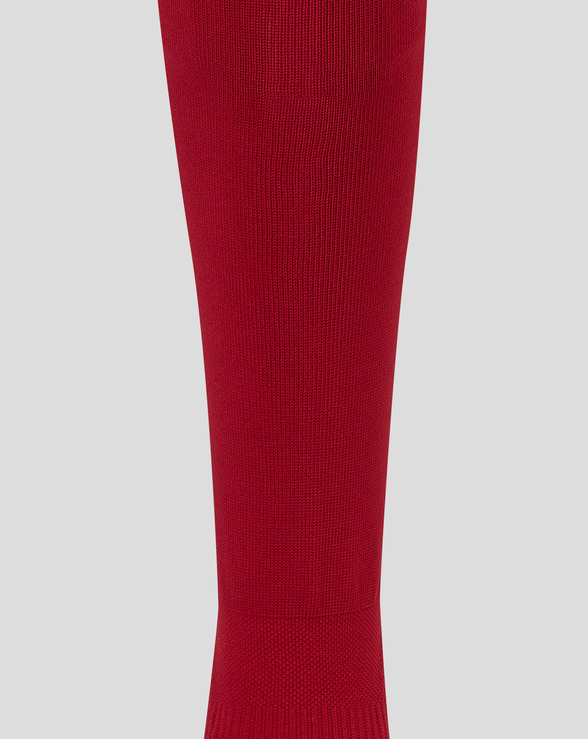 A close-up of a ribbed knit red sock or leg sleeve shown vertically against a light gray background.