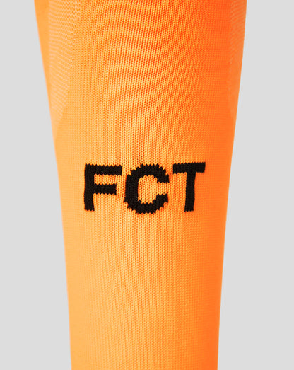 Close up of bright orange FC Twente goalkeeper sock with black FGT lettering