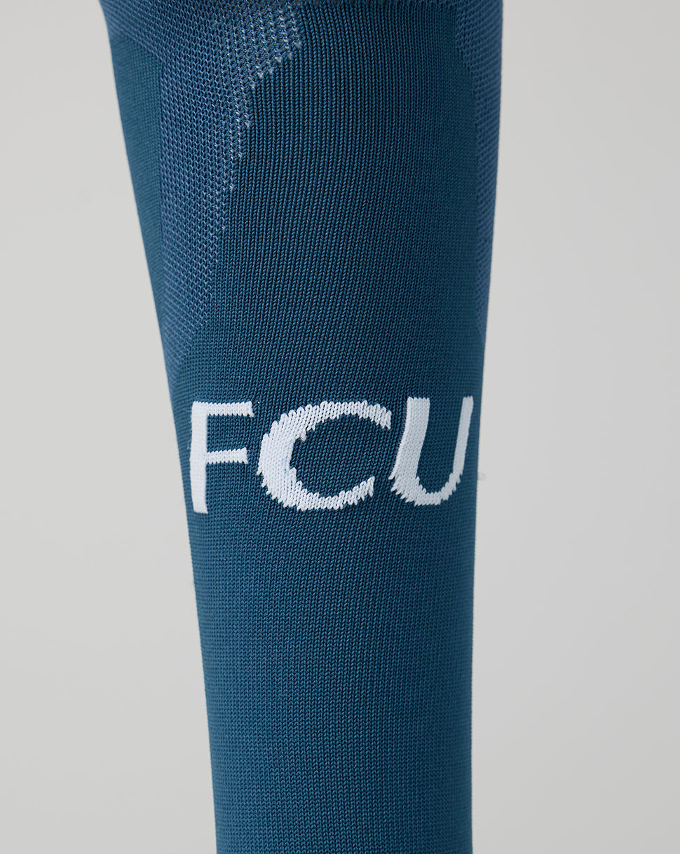 FC Utrecht away sock in teal shown on a leg with FCU initials on the shin