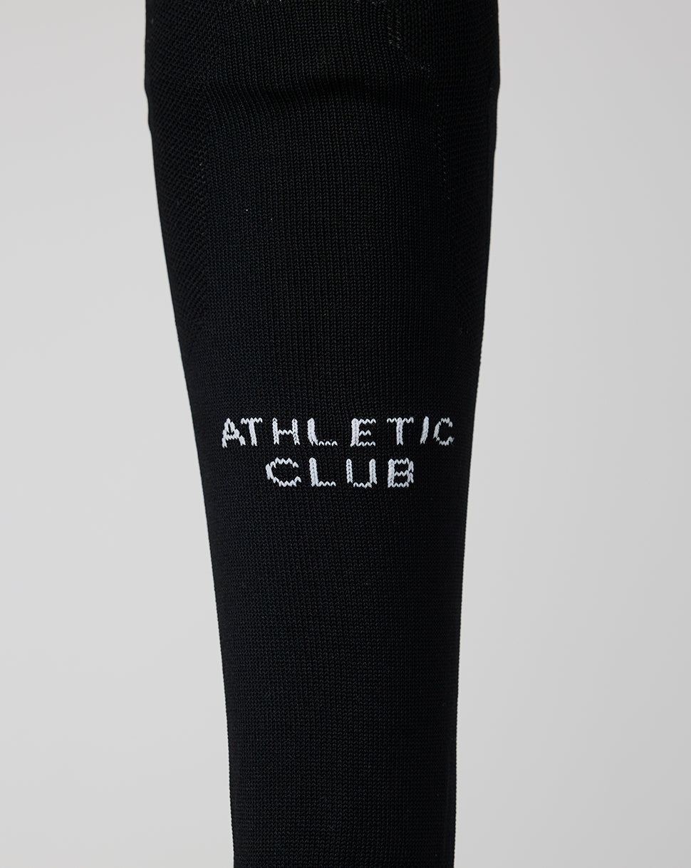 Close-up of a black Athletic Club junior home goalkeeper sock with white lettering.