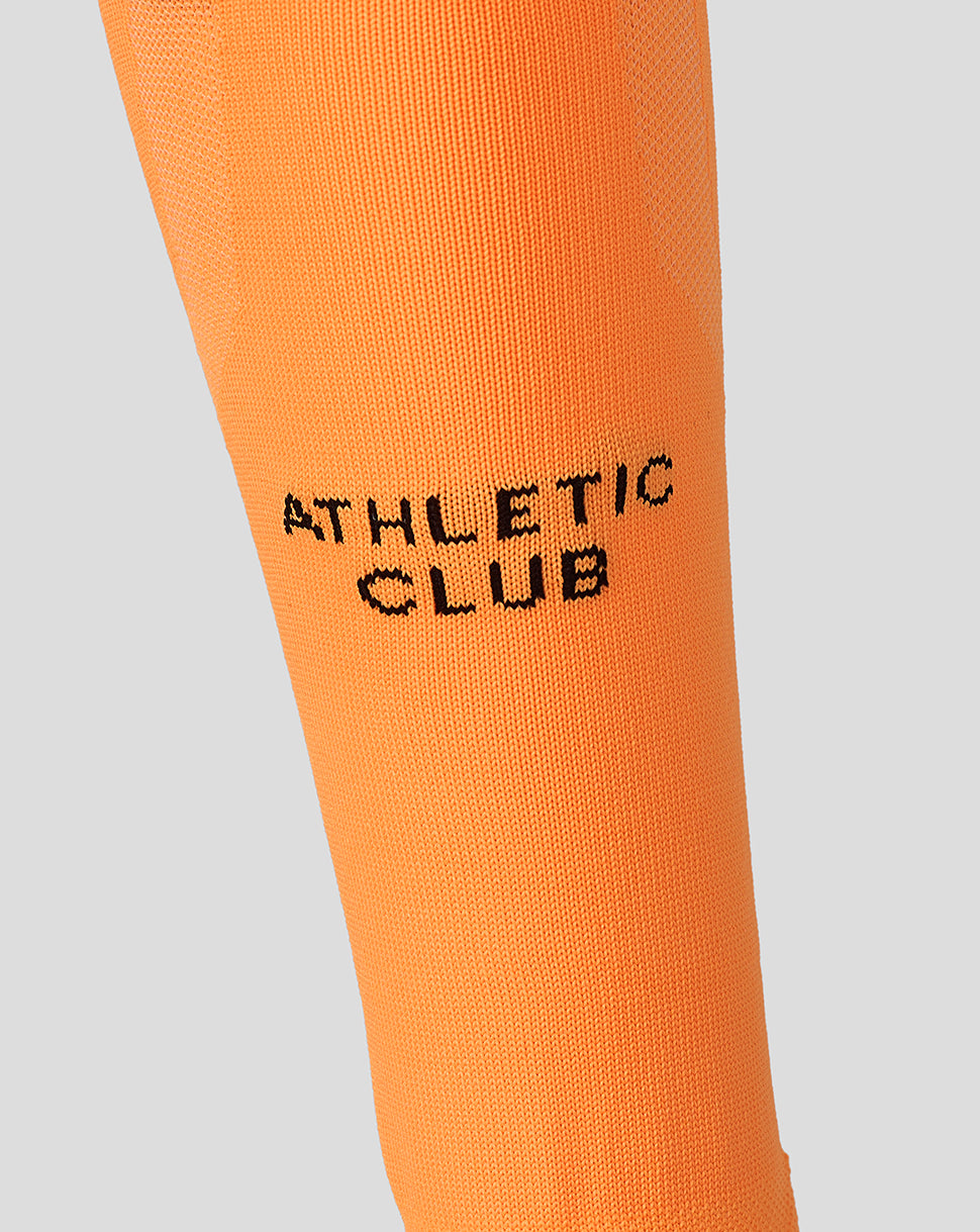 Close-up of orange unisex Athletic Club third goalkeeper sock showing black branding text along the leg.