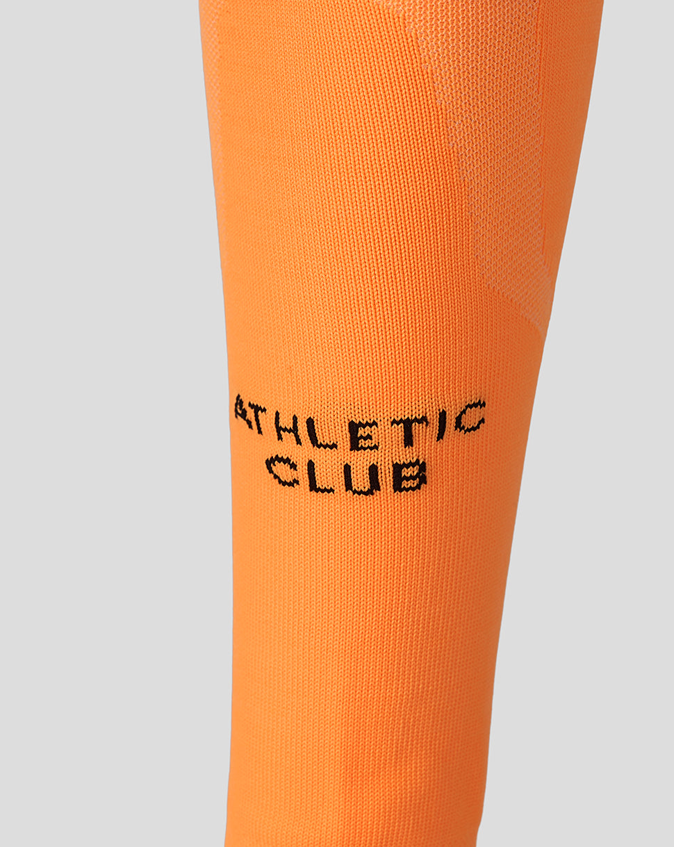 Bright orange Athletic Club footless sock close-up highlighting knit texture and branding