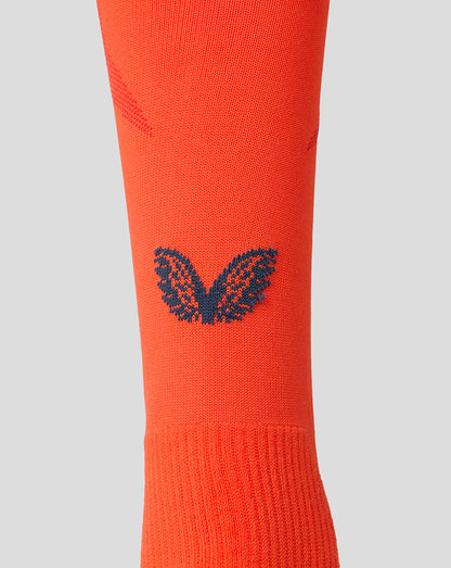 Bright orange Feyenoord third sock close up with navy F crest on the shin and Castore logo on the calf
