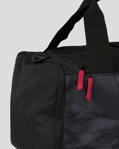 Black duffel bag with a red tag on a light gray background
