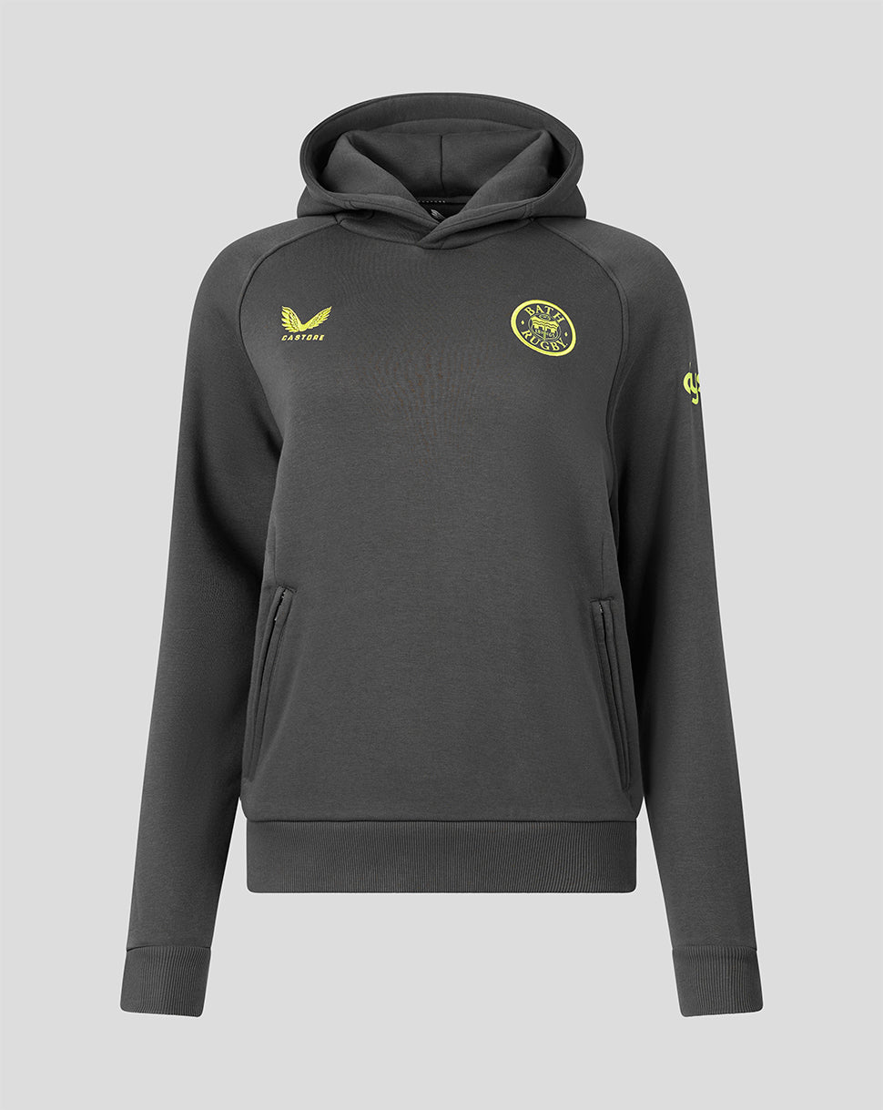 A dark gray pullover hoodie with yellow accents, featuring a yellow Castore logo on the right chest and a circular yellow crest on the left chest, displayed against a solid gray background.