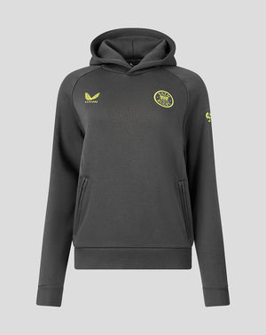 A dark gray pullover hoodie with yellow accents, featuring a yellow Castore logo on the right chest and a circular yellow crest on the left chest, displayed against a solid gray background.