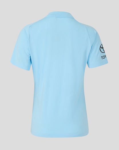 Light blue polo shirt with a brand logo on the sleeve against a light gray background