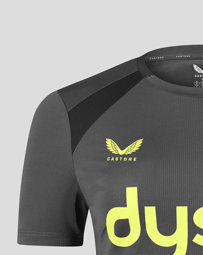 Close-up of a dark gray Castore athletic jersey with a yellow wing logo and the word 'CASTORE' on the chest, featuring a black shoulder panel and a large yellow 'dys' logo on the front.
