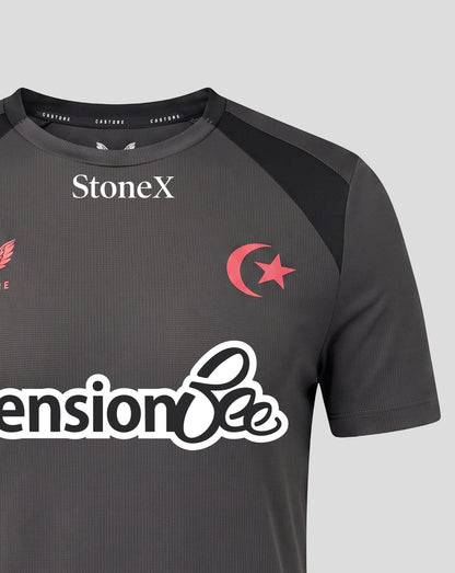 A close-up of a dark gray athletic jersey with black shoulder panels, featuring the white StoneX logo on the chest, a red crescent and star emblem, and a large white 'Pension Bee' sponsor logo across the front.