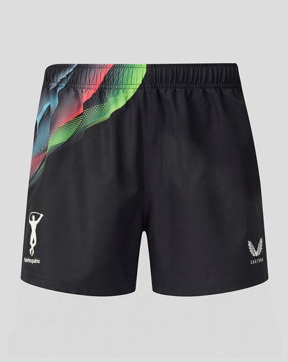 Black athletic shorts featuring a vibrant, abstract multicolor graphic print on the left side, with white logos for 'Harlequins' on the left leg and 'Castore' on the right leg, displayed against a neutral gray background.