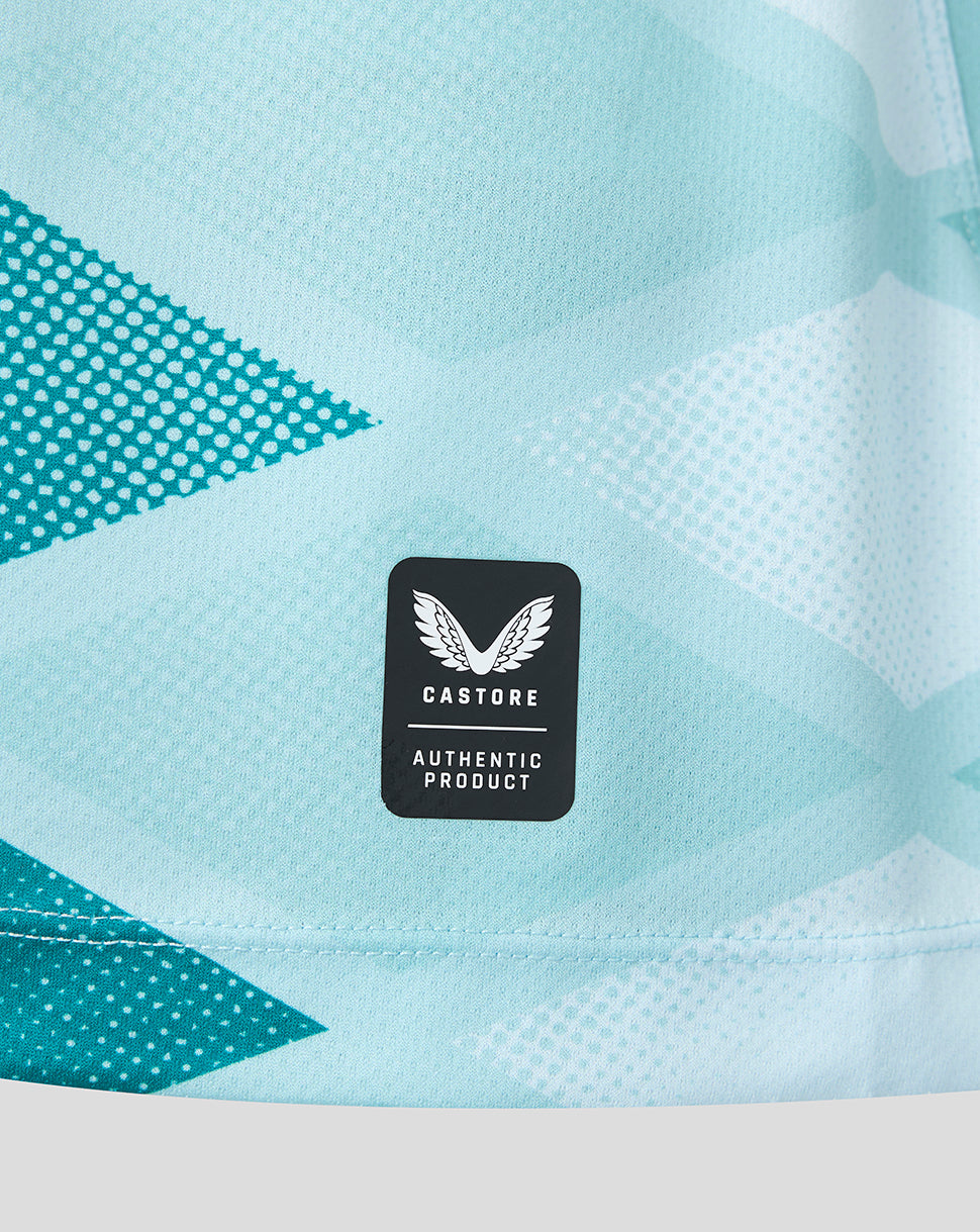 Close-up of a light blue and white patterned athletic garment with a black Castore Authentic Product label on the front.