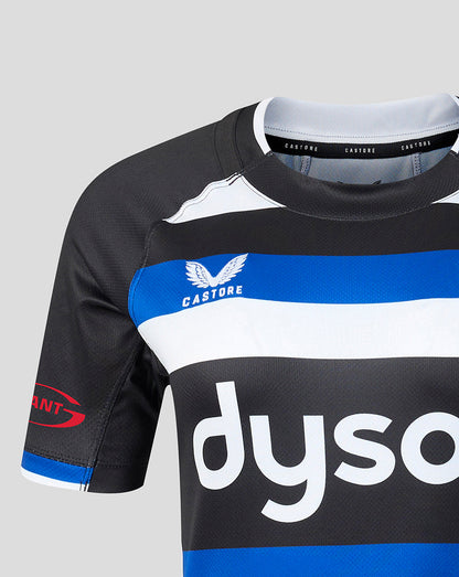 Close-up of a rugby jersey in black, white, and blue, featuring the Castore brand logo and a partial Dyson sponsor logo on a light gray background.