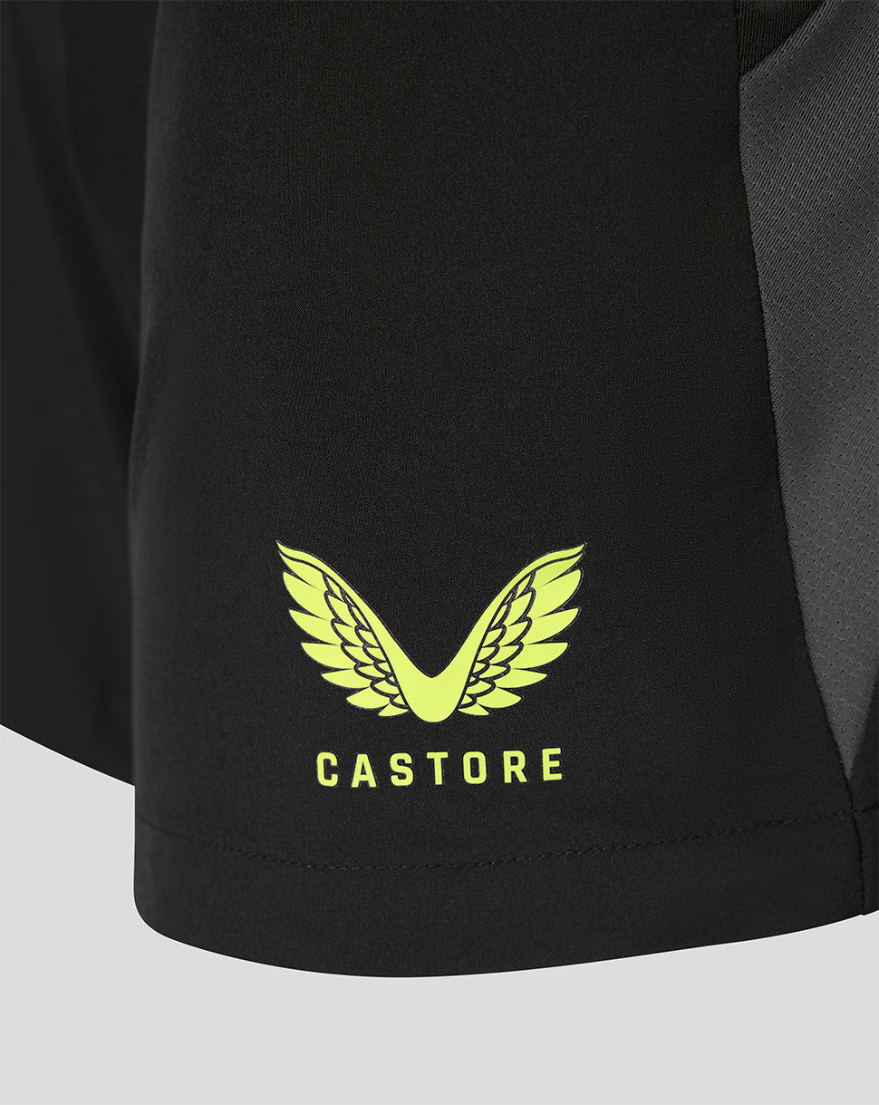 Close-up of a black athletic garment showing a bright yellow wing logo and the word CASTORE below it, on a light gray background.
