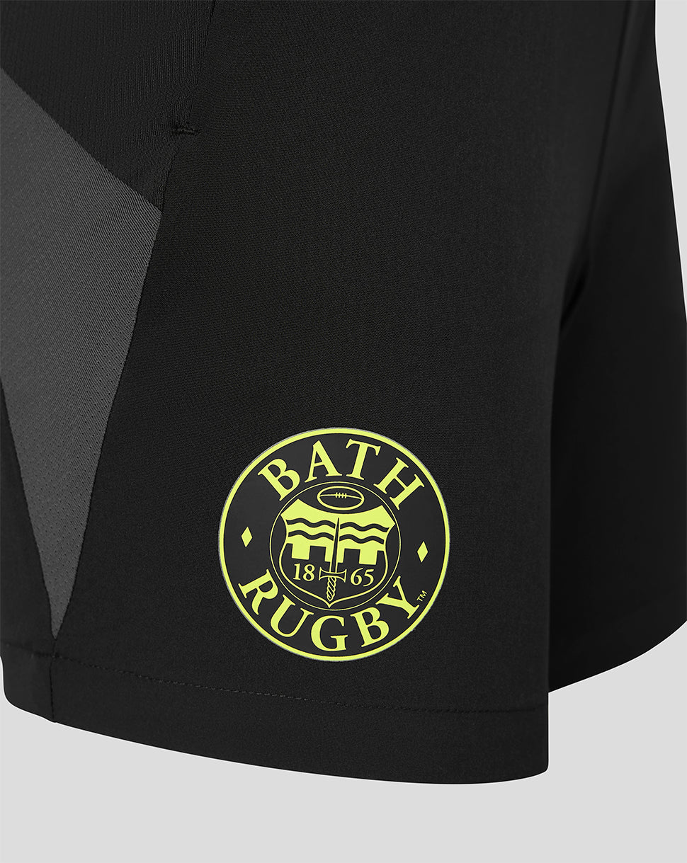 Close-up of a black athletic shorts leg featuring a circular yellow 'BATH RUGBY' crest logo on the lower left leg.