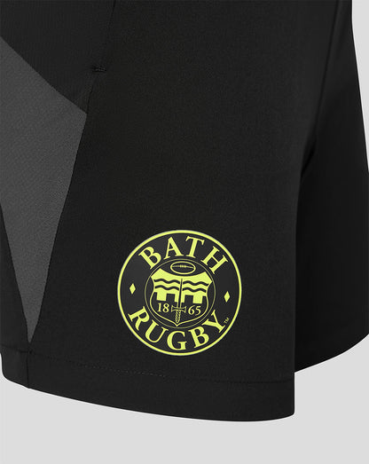 Close-up of a black athletic shorts leg featuring a circular yellow 'BATH RUGBY' crest logo on the lower left leg.