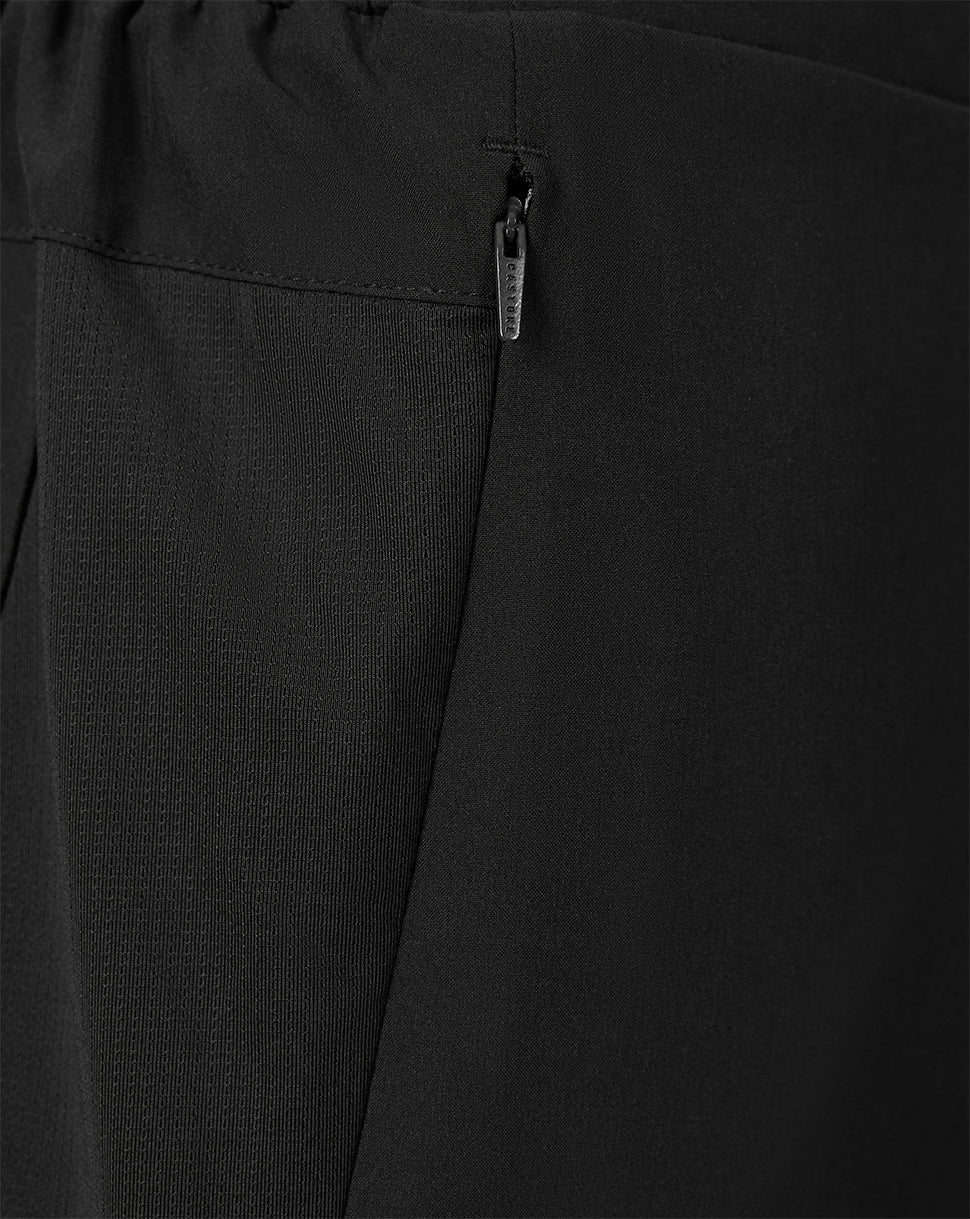 Close-up of black textured fabric with an elastic waistband and a small silver zipper pull.
