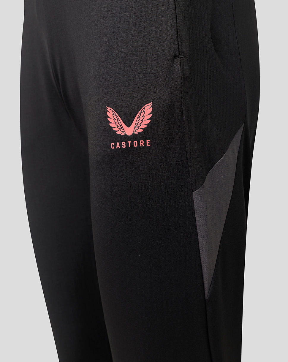 Close-up of black athletic pants featuring a pink Castore wing logo and text on the left thigh, with a dark gray mesh side panel.