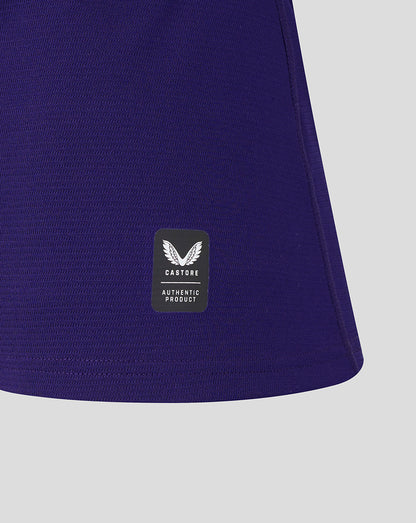 Close-up of a purple garment with a visible brand label on a light gray background
