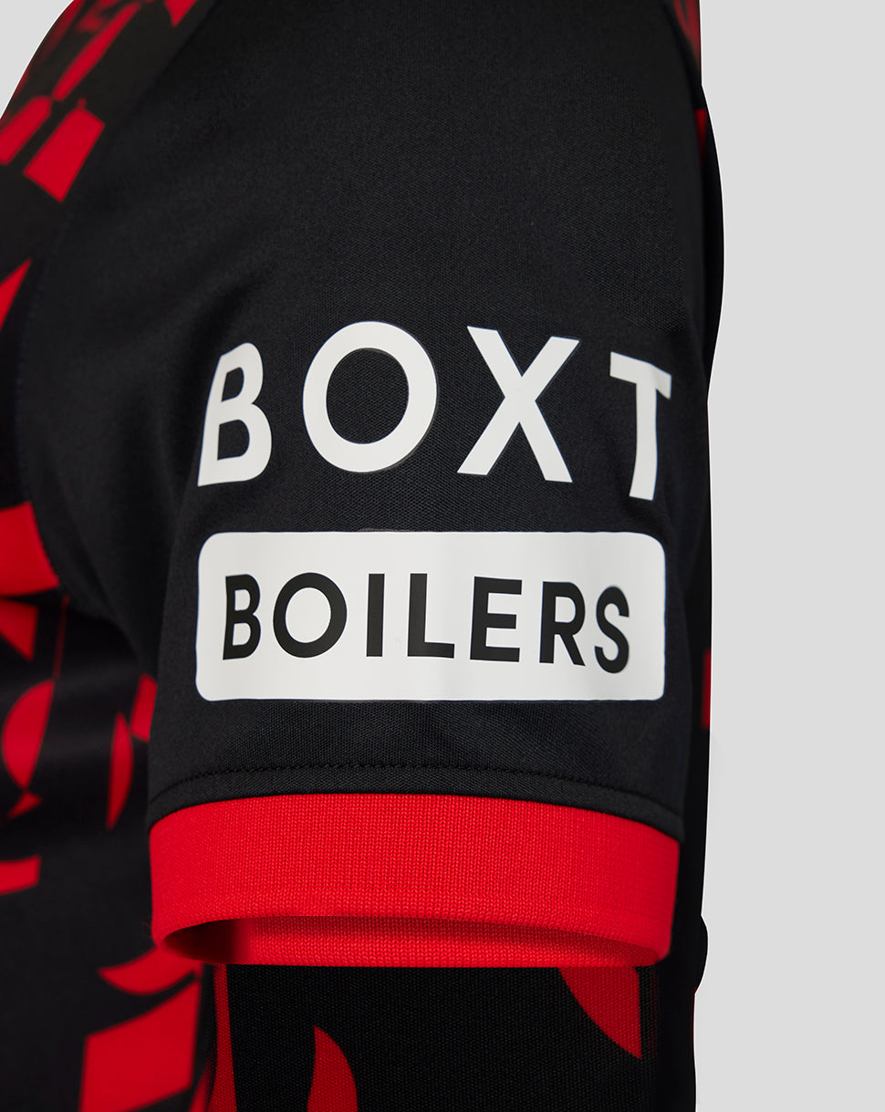 Close-up of a black and red patterned sports jersey sleeve featuring a white rectangular patch with the text 'BOXT BOILERS' in black lettering.
