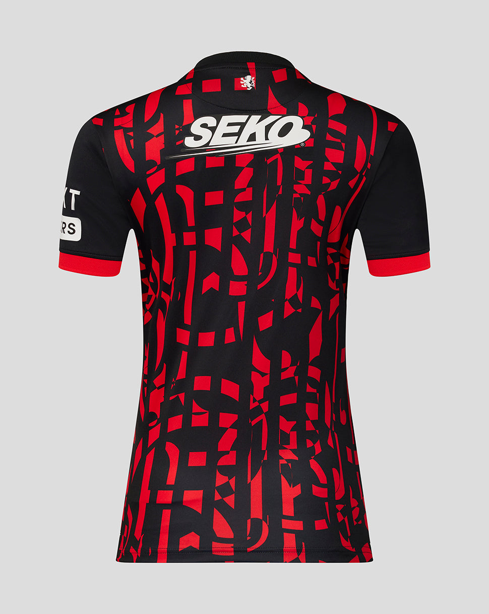 A short-sleeve football top shown from the back, featuring a black base with a bold red abstract geometric pattern, a white SEKO logo across the upper back, and red trim at the collar and sleeve cuffs, set against a solid gray background.