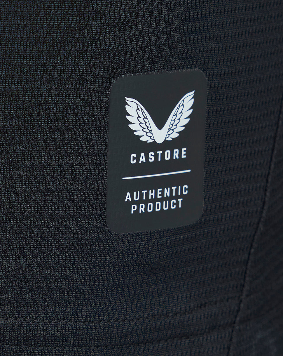 Close-up of Castore authentic product label on textured black fabric of the away shirt