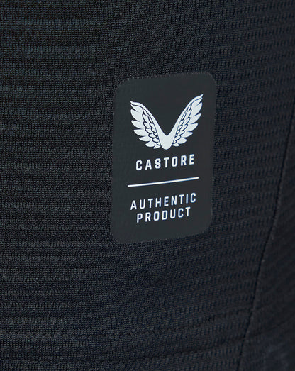 Close-up of Castore authentic product label on textured black fabric of the away shirt