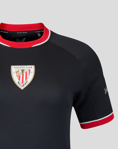 Close up of navy away shirt sleeve and chest highlighting the crest and red cuff trim.