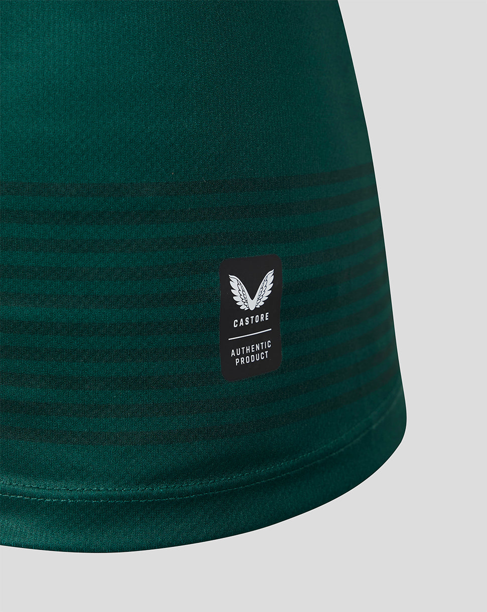 Close-up of a dark green athletic garment with horizontal tonal stripes and a black Castore Authentic Product label on the side, shown against a light gray background.