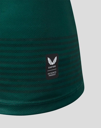 Close-up of a dark green athletic garment with horizontal tonal stripes and a black Castore Authentic Product label on the side, shown against a light gray background.