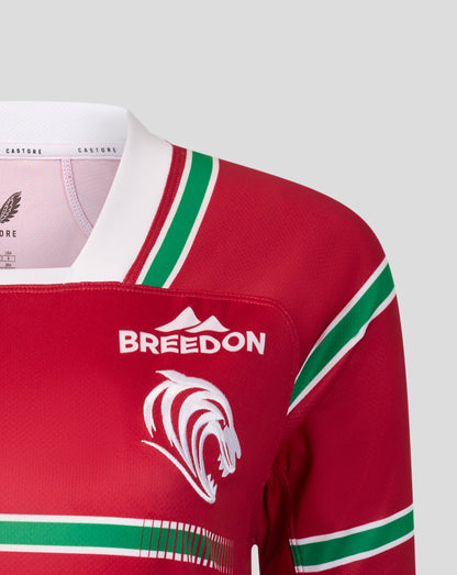 Close-up of a red long-sleeve sports jersey with green and white stripes, featuring a white 'BREEDON' logo and a white animal head graphic on the chest.