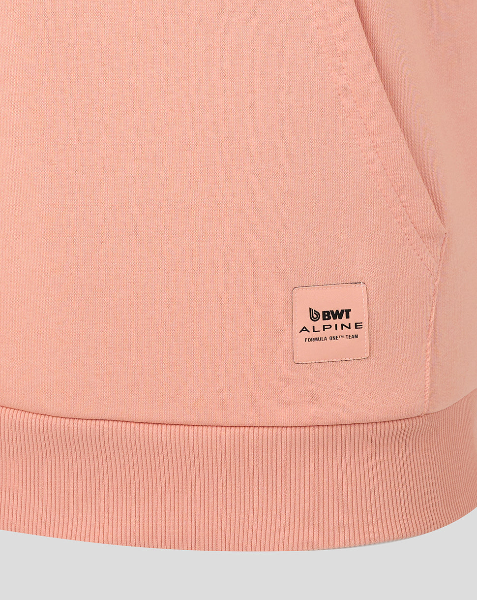 Close up of the peach pink hoodie hem showing a BWT Alpine patch near the lower side