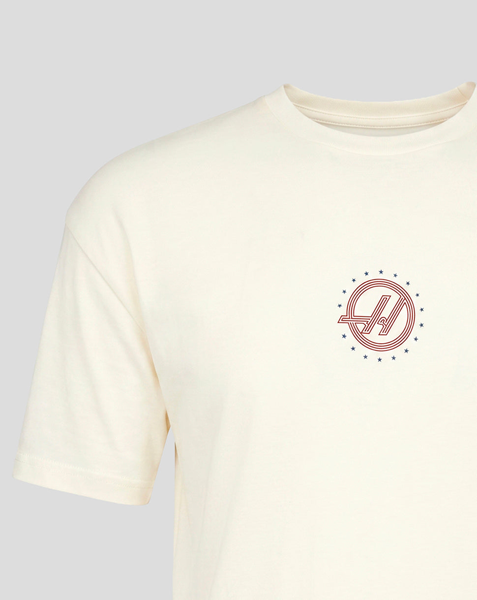 Small circular red Haas F1 Team roundel with blue stars on left chest of white T shirt.