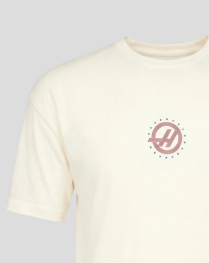 Small circular red Haas F1 Team roundel with blue stars on left chest of white T shirt.