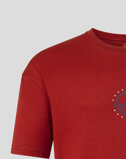 Close-up of a red short-sleeve crewneck t-shirt showing the chest area with a small dark graphic and white stars on the left chest, set against a light gray background.